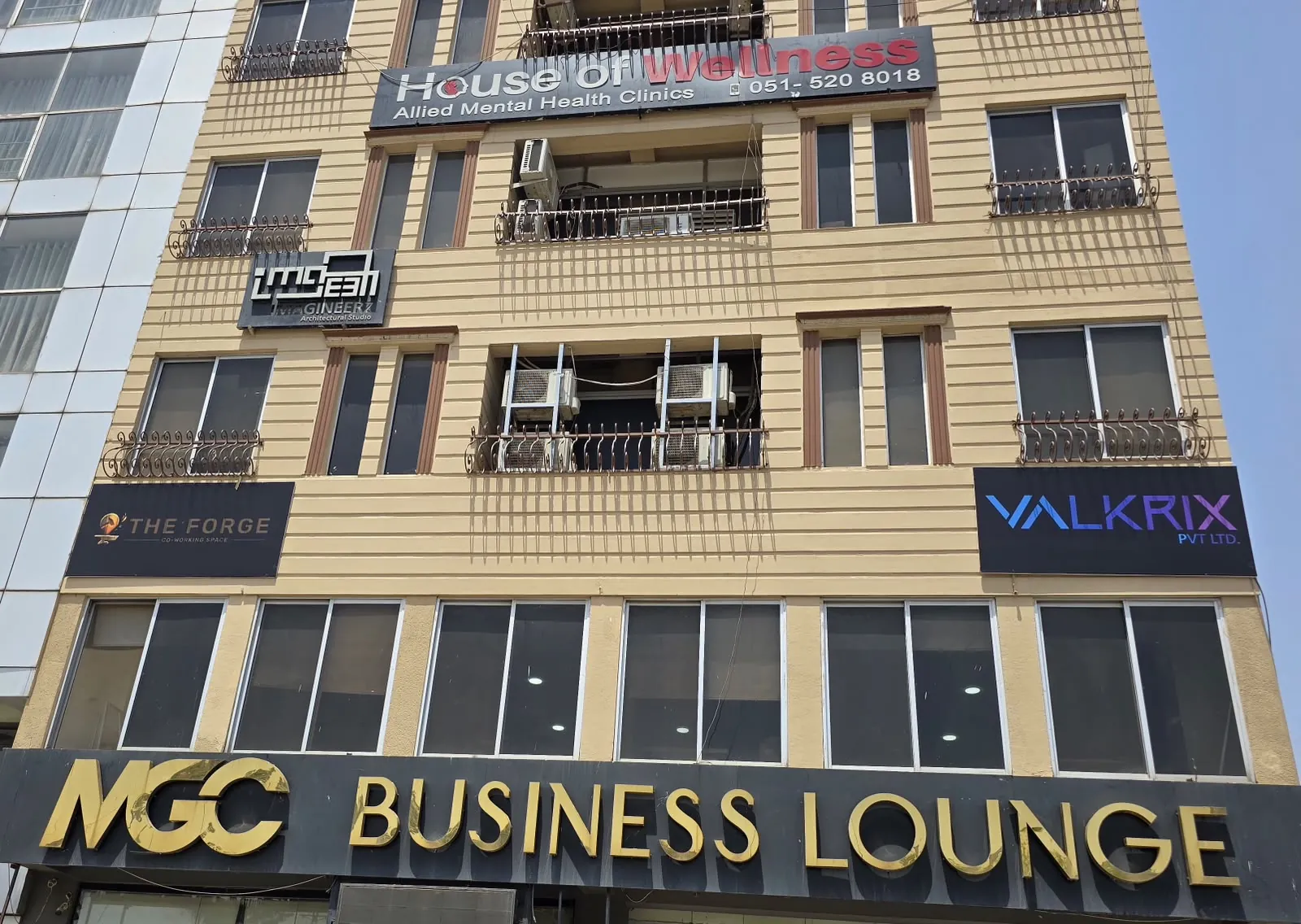 The front of a commercial building in Islamabad with a The Forge sign on the left and a Valkrix sign on the right.